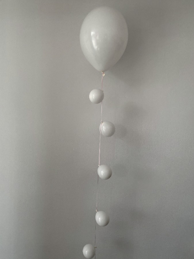 Biały balon lateksowy z małymi balonami na sznurku