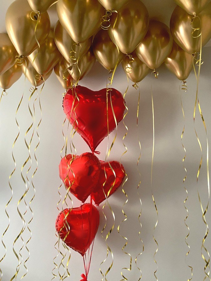 Czerwone serca oraz 18 balonów w złotym kolorze pod sufitem